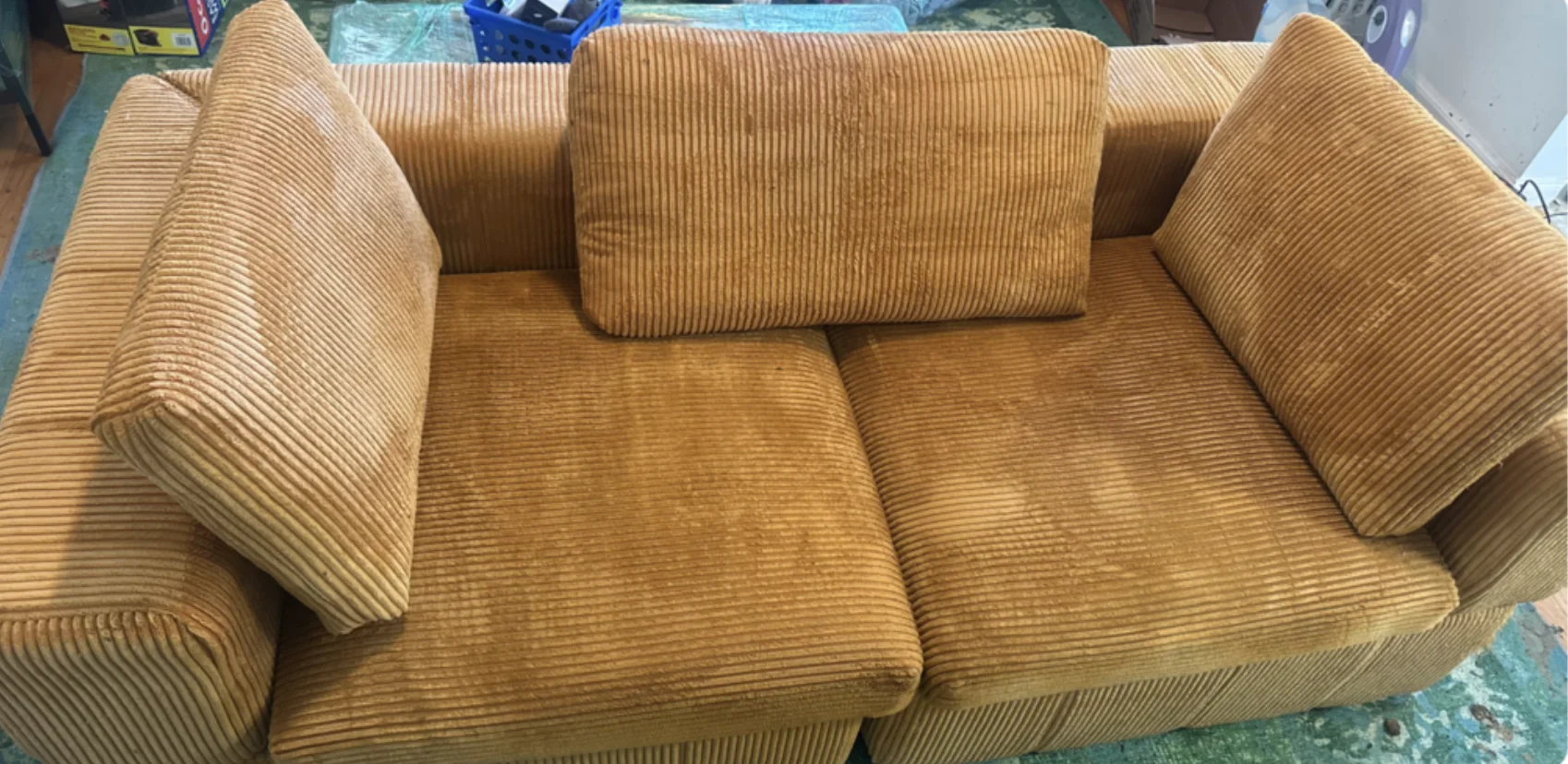 The same mustard corduroy couch after cleaning, with the upholstery refreshed and reassembled